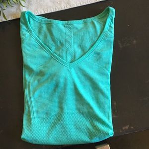 Teal tight fitting lululemon T-shirt.